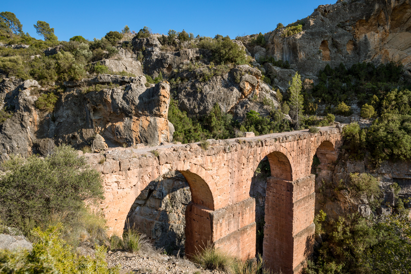 Vista de los arcos del acueducto de Peña Cortada y su entorno rocoso