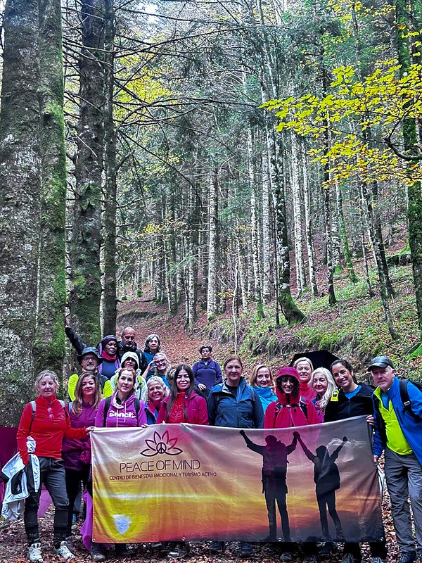 Participantes del grupo con ropa de senderismo durante una salida por el bosque